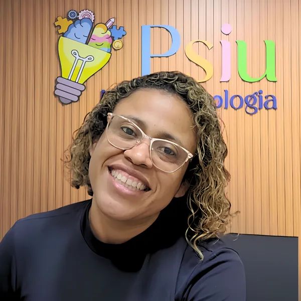 Viviane sorrindo em frente ao letreiro da Psiu Neuropsicologia